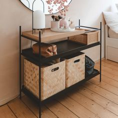 a wooden shelf with baskets under a mirror