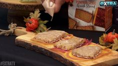 a wooden cutting board topped with two pieces of bread next to a box of pumpkin spice