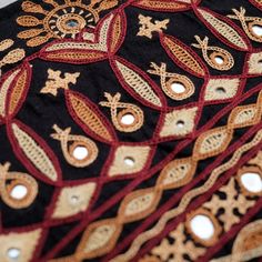 closeup of an intricately designed black and red cloth with gold trimmings