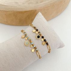 two gold bracelets sitting on top of a pillow