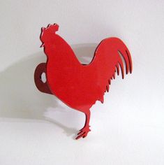 a red rooster is standing on its hind legs and has it's tail curled up