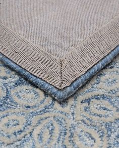 a close up view of the corner of a rug with blue and white designs on it