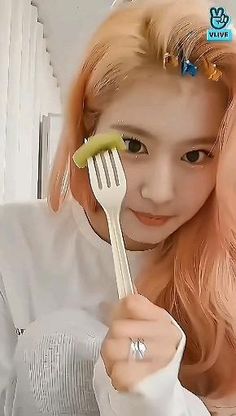 a woman holding a fork and looking at the camera