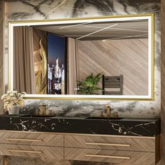 a bathroom vanity with a large mirror above it and a plant on the counter top