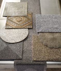 carpet samples laid out on top of each other in various colors and patterns, including gray