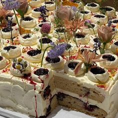 there is a cake that has been decorated with flowers and berries on the top layer