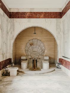an old fireplace in a room with marble walls and flooring that has red and white stripes on it