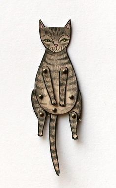 a cat brooch sitting on top of a white surface