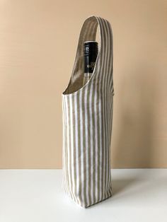 a bottle in a striped bag on a table