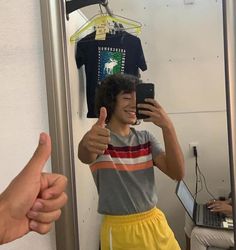 a man taking a selfie in front of a mirror with his hand up to the camera