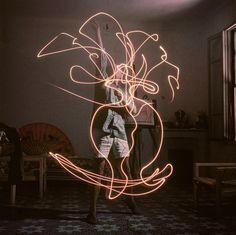 a person standing in a room with light painting on their body and hands behind them