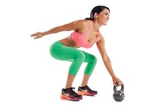 a woman is doing squats with a kettle