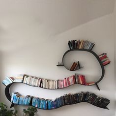 a bookshelf with many books on it and a plant in the corner