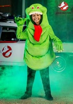 a man dressed in a green costume standing next to a car