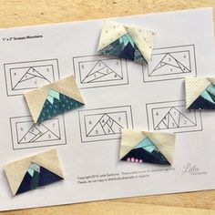 four pieces of origami sitting on top of a piece of paper