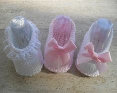 three pairs of baby shoes with bows on them