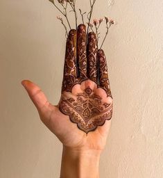 a person holding up their hand with some flowers in the middle of it and an intricate design on its palm