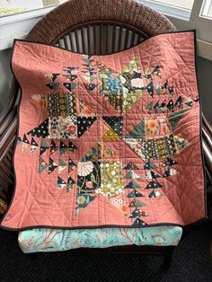 a pink quilt sitting on top of a wooden chair