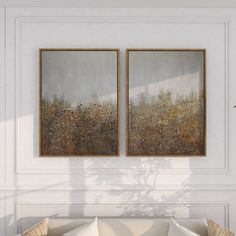 two paintings hanging on the wall above a couch in a room with white walls and flooring