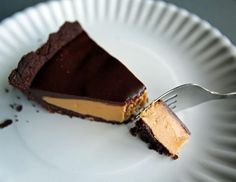 a piece of chocolate cheesecake on a paper plate with a fork