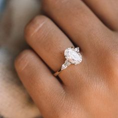 a woman's hand with a diamond ring on it