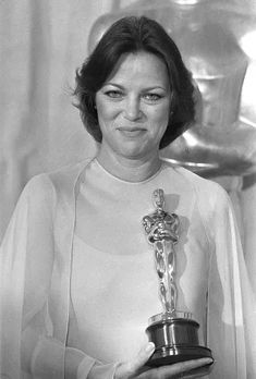 an old photo of a woman holding up her oscar award for best actress in a supporting role