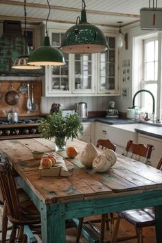 a kitchen with an old wooden table and green lights hanging from it's ceiling