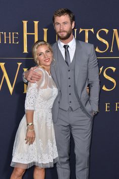 a man and woman standing next to each other on a red carpet