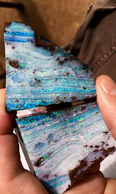 a person holding a piece of blue and white opalite