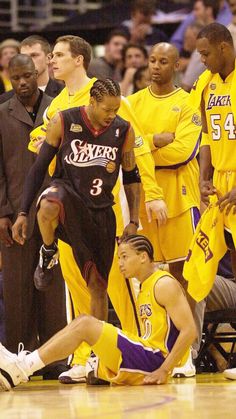 the basketball players are sitting on the floor with their feet in the air as they talk to each other