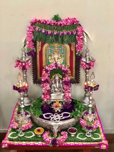 the altar is decorated with pink flowers and other decorations on it's side table