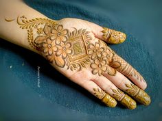 a woman's hand with henna on it and flowers painted on the palm