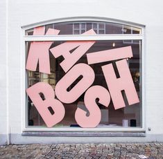 a pink sign that says boss in front of a window with the word boss painted on it