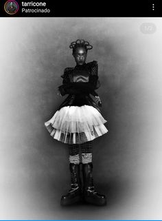 a black and white photo of a woman in tights with boots on her feet