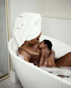a woman in a bathtub holding a baby