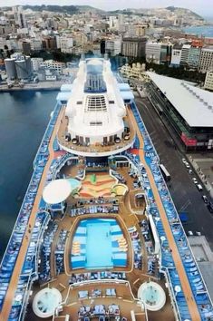the top deck of a cruise ship with water and buildings in the backgroud