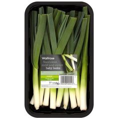 leeks in a plastic container on a white background