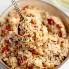 a spoon full of oatmeal is being held over the top of it