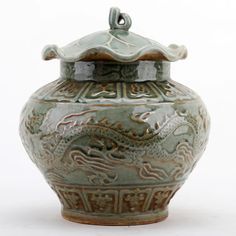 a green vase with a dragon design on the top and bottom, sitting against a white background