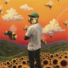 a man standing in front of a field of sunflowers with bees flying over him