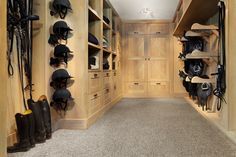 a large walk - in closet with lots of hats and boots on the shelves next to it