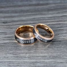 two gold wedding rings with words engraved on them