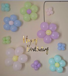 balloons and streamers are arranged on the wall for a happy birthday message to someone