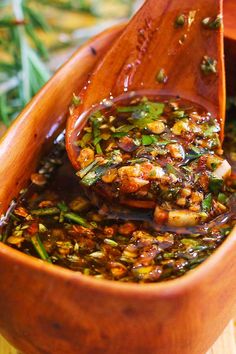 a wooden spoon filled with food on top of a table