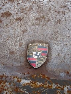 an emblem on the side of a car that is rusted and chipped off