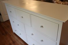 a white dresser sitting on top of a hard wood floor