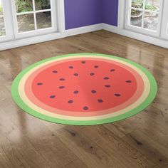 a watermelon rug is on the floor in front of two windows with purple walls