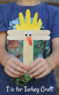 a child holding a wooden stick with a chicken on it