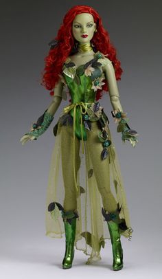 a doll with red hair and green skin is dressed in a costume that has flowers on it