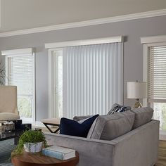 a living room filled with furniture and windows covered in blinds